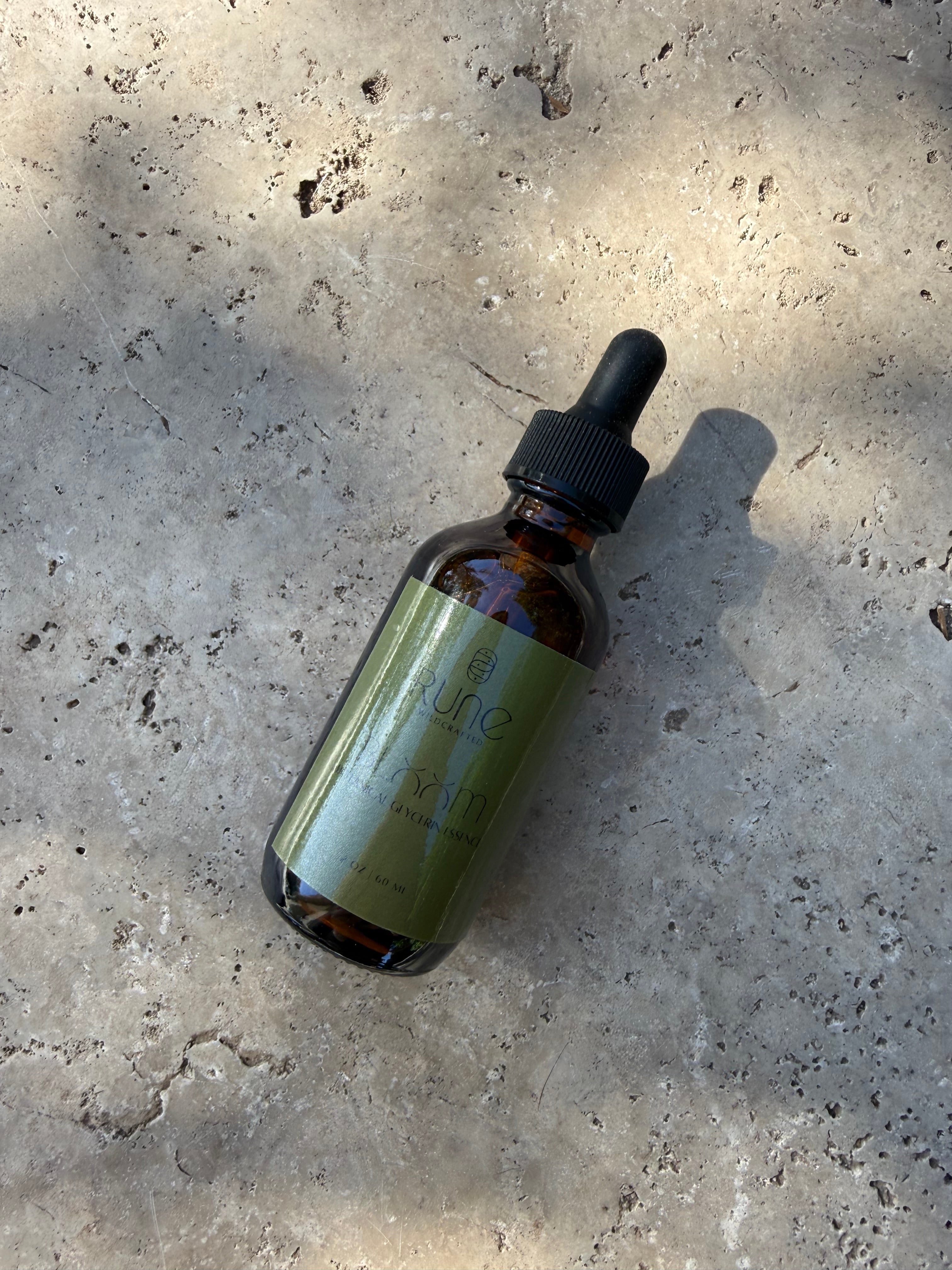 Glass dropper bottle with a metal cap on a textured concrete surface